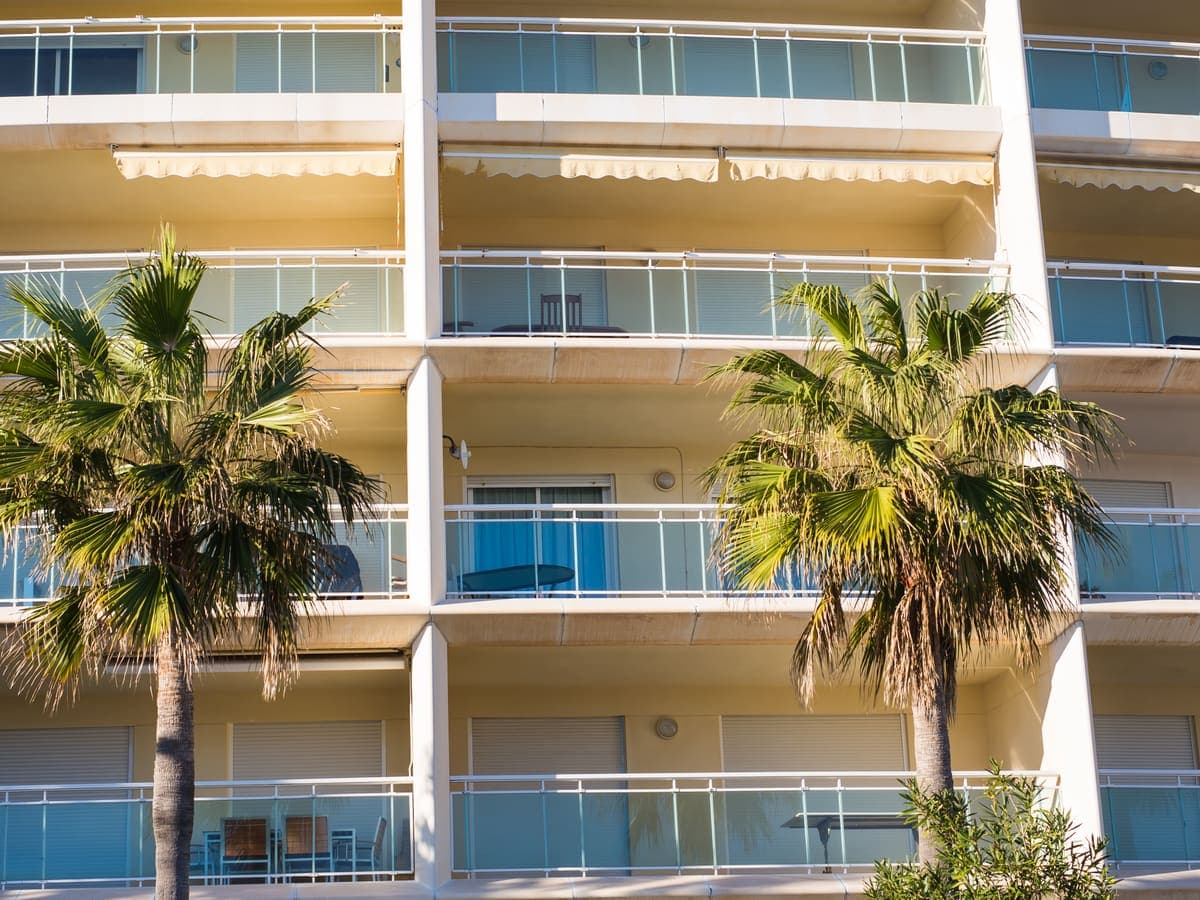A Florida condo building with balconies and palm trees