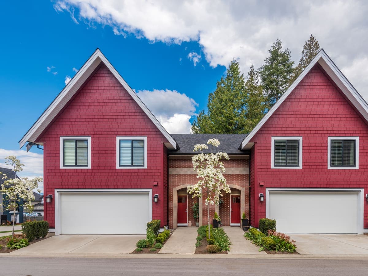 A two-unit home with twin entrances and a green lawn