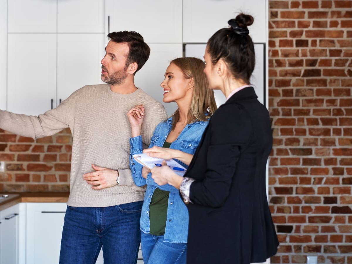 A real estate agent showing a home to a couple