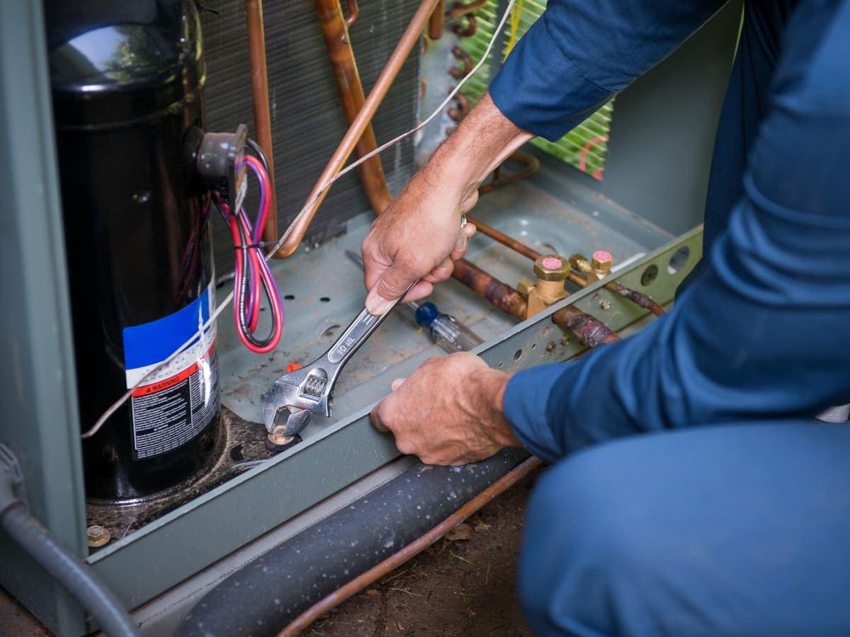 A technician repairing an air conditioning unit