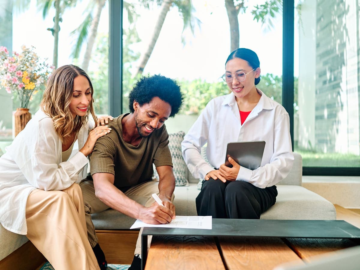 A couple reviewing an offer with their agent at a table